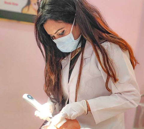 Dr. Poonam Arya providing acne treatment to a patient in her clinic