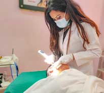 Dr. Poonam Arya providing acne treatment to a patient in her clinic